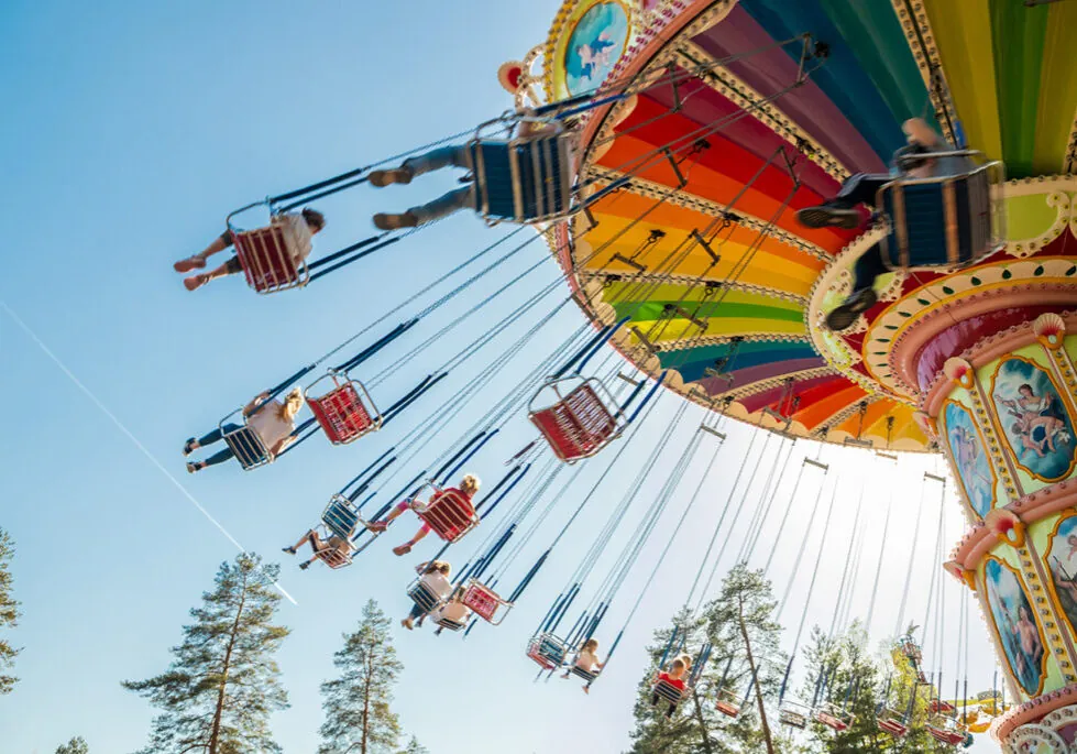 Image of adults and children on an amusement park swing ride