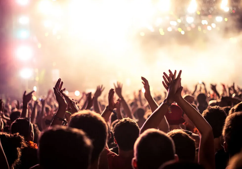 Silhouettes of a concert crowd cheering the musical artist