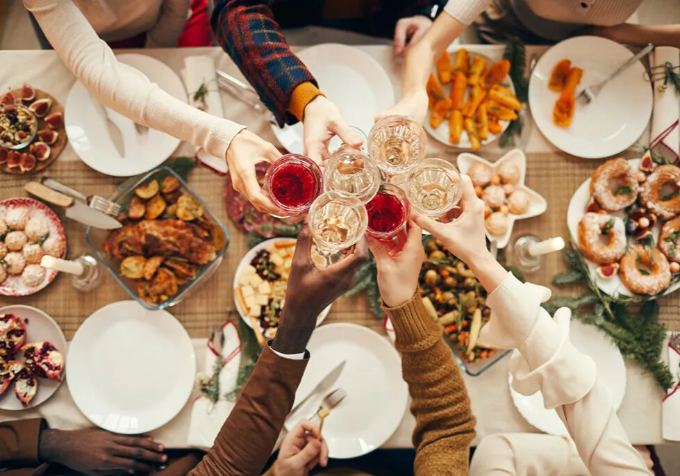 Group of people toasting above a holiday party spread