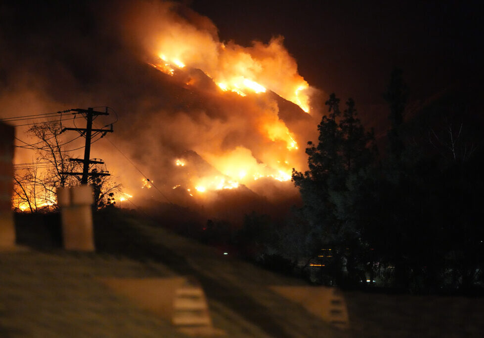 View of a wildfire on a mountainside from a sidewalk